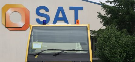 Cabine jaune devant logo et société SAT